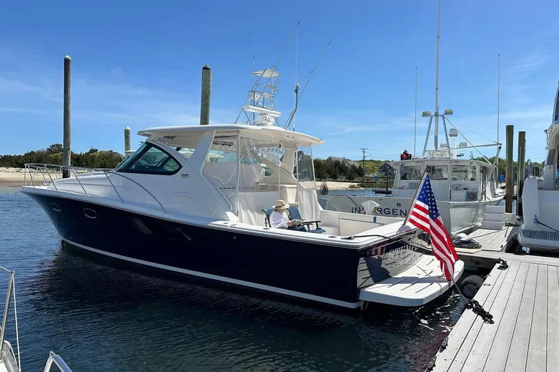 Slide: The Image of 2012 Tiara Yachts 3900 Open docked, featuring sleek design and American flag. - 31