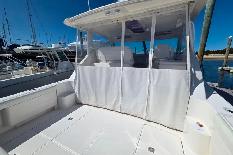 Slide: The Image of 2012 Tiara Yachts 3900 Open with covered cockpit, docked at marina under clear blue sky. - 7