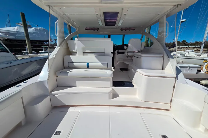Slide: The Image of 2012 Tiara Yachts 3900 Open interior with seating and helm, docked at marina. - 8