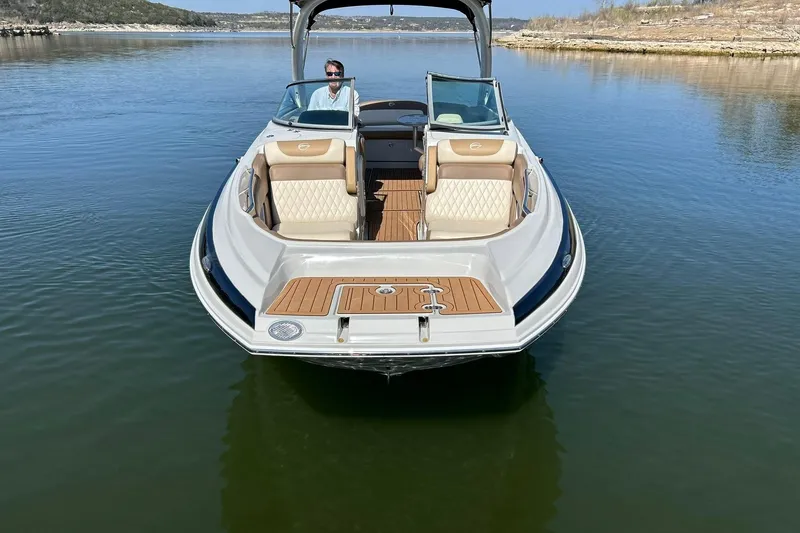 Slide: The Image of 2019 Crownline Eclipse E285 boat on calm water, featuring luxurious seating and sleek design. - 12