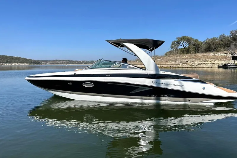 Slide: The Image of 2019 Crownline Eclipse E285 boat on a calm lake under clear blue sky. - 17