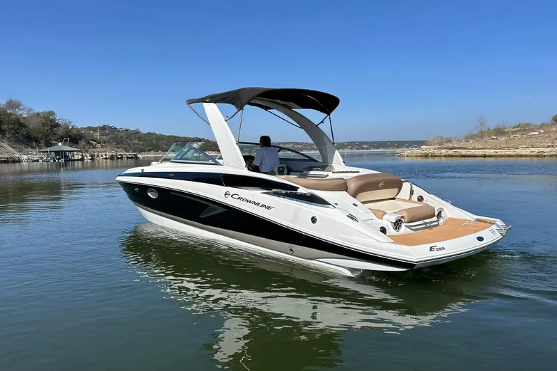 Slide: The Image of 2019 Crownline Eclipse E285 boat cruising on a calm lake under clear blue skies. - 18