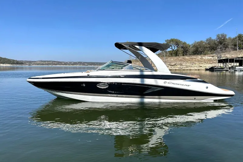 Slide: The Image of 2019 Crownline Eclipse E285 boat on calm lake under clear blue sky. - 2