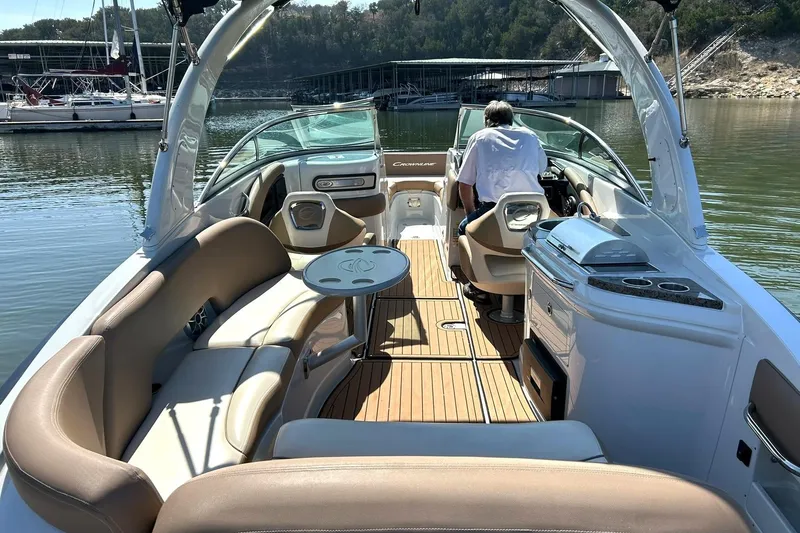 Slide: The Image of 2019 Crownline Eclipse E285 boat interior with seating, table, and grill on a sunny day. - 20