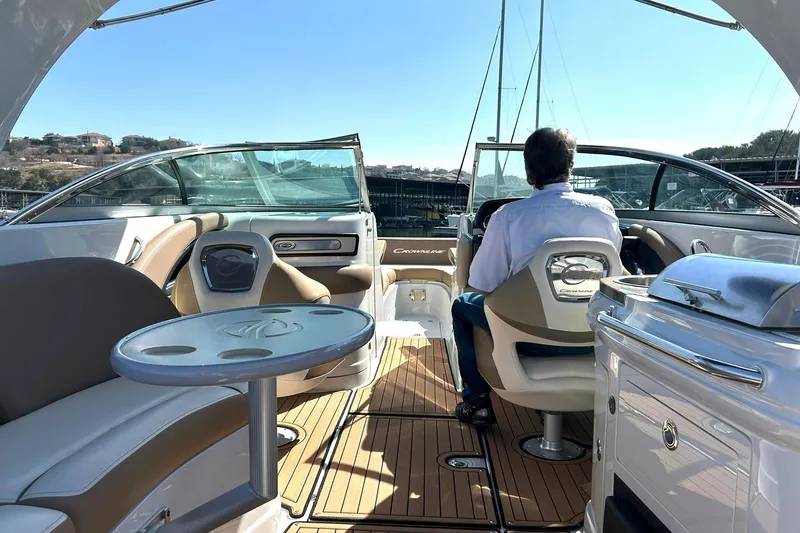 Slide: The Image of 2019 Crownline Eclipse E285 boat interior with driver, featuring seating and table. - 28