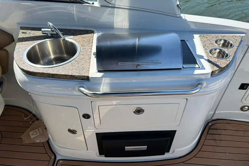Slide: The Image of 2019 Crownline Eclipse E285 boat kitchenette with sink, grill, and cup holders. - 30