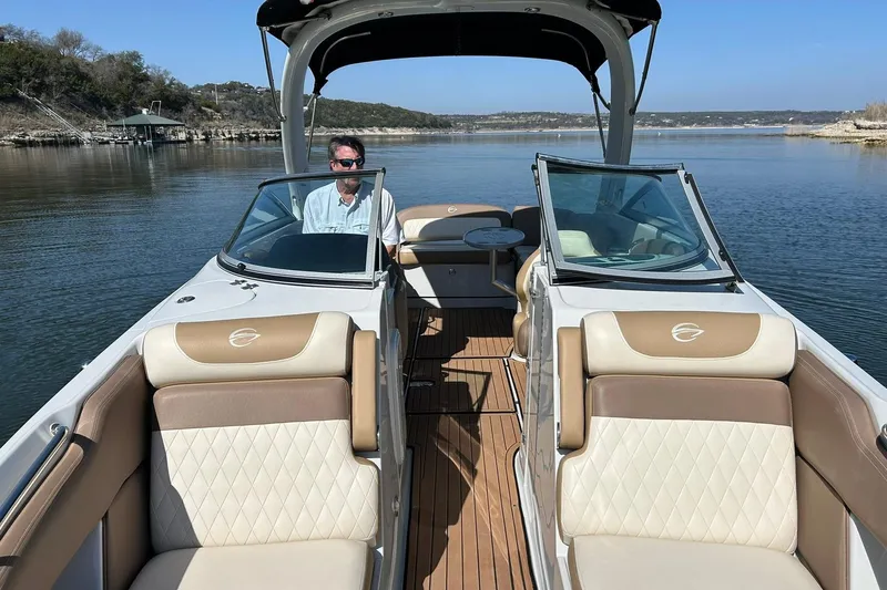 Slide: The Image of 2019 Crownline Eclipse E285 boat on a serene lake with luxurious seating. - 4