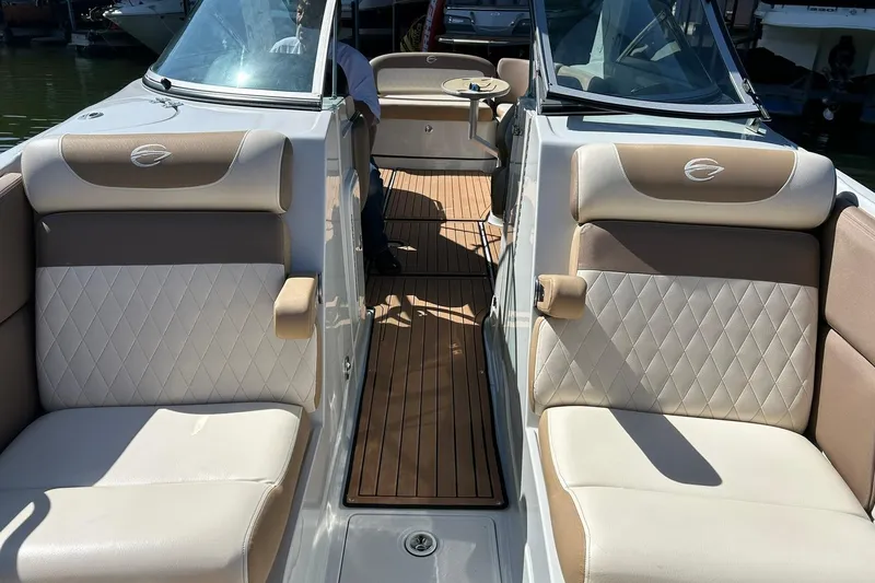 Slide: The Image of 2019 Crownline Eclipse E285 boat interior with beige seating and wooden flooring. - 44