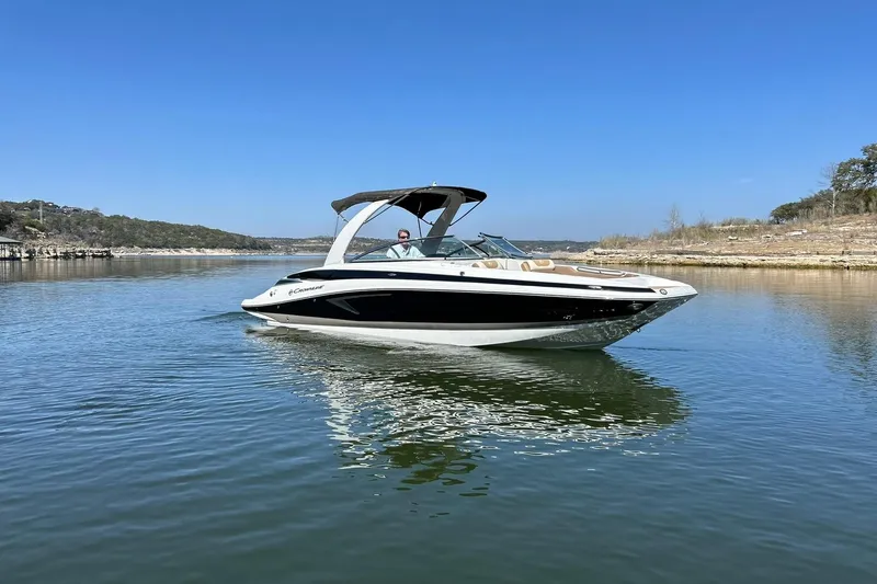 Slide: The Image of 2019 Crownline Eclipse E285 boat cruising on a calm lake under a clear blue sky. - 9