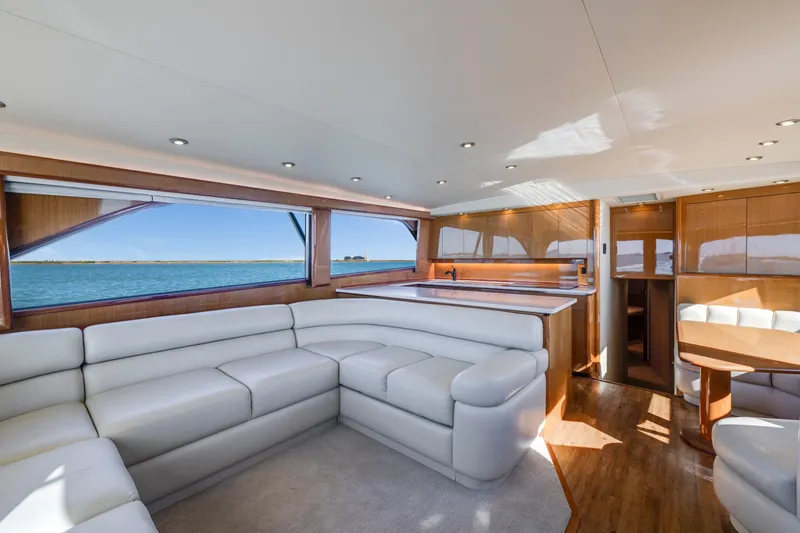 Slide: The Image of Luxurious interior of a 2002 Viking Convertible yacht with white leather seating and wooden accents. - 18