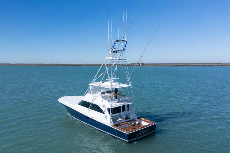 Slide: The Image of 2002 Viking Convertible yacht on calm blue waters under clear sky. - 2