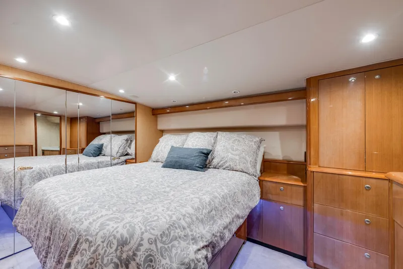 Slide: The Image of Luxurious bedroom interior in 2002 Viking Convertible yacht with elegant wood cabinetry and mirrored closet. - 25