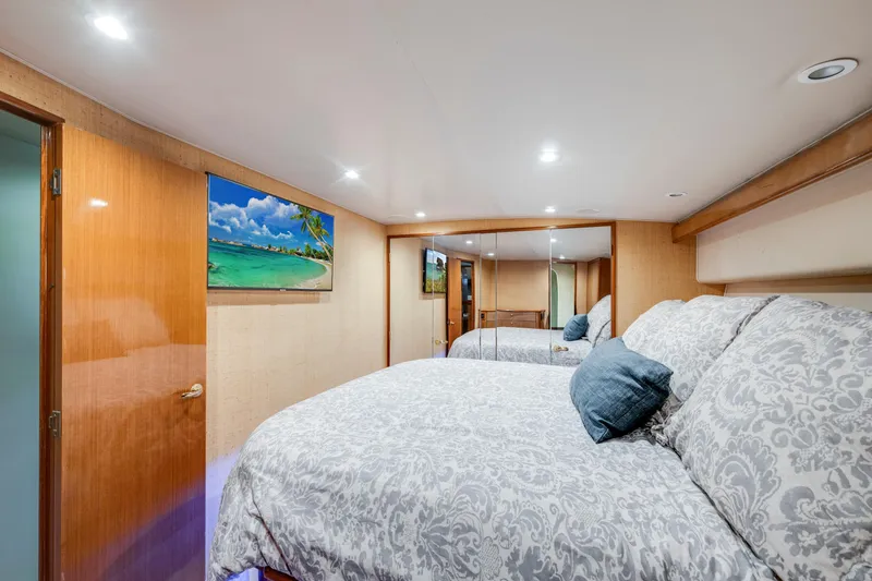 Slide: The Image of Luxurious bedroom interior in 2002 Viking Convertible yacht with elegant bedding and mirrored closet. - 27