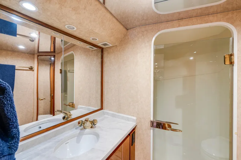 Slide: The Image of Luxurious bathroom in 2002 Viking Convertible yacht with marble countertop and glass shower. - 28
