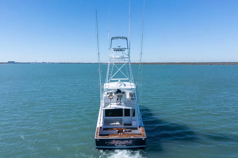 Slide: The Image of 2002 Viking Convertible yacht cruising on open water under clear blue skies. - 3
