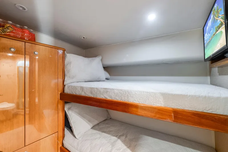 Slide: The Image of Cozy 2002 Viking Convertible cabin with bunk beds, wooden cabinetry, and wall-mounted TV. - 30
