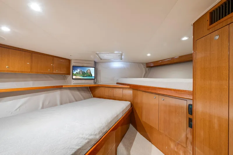 Slide: The Image of Luxurious 2002 Viking Convertible yacht cabin with wood finishes and cozy bedding. - 32