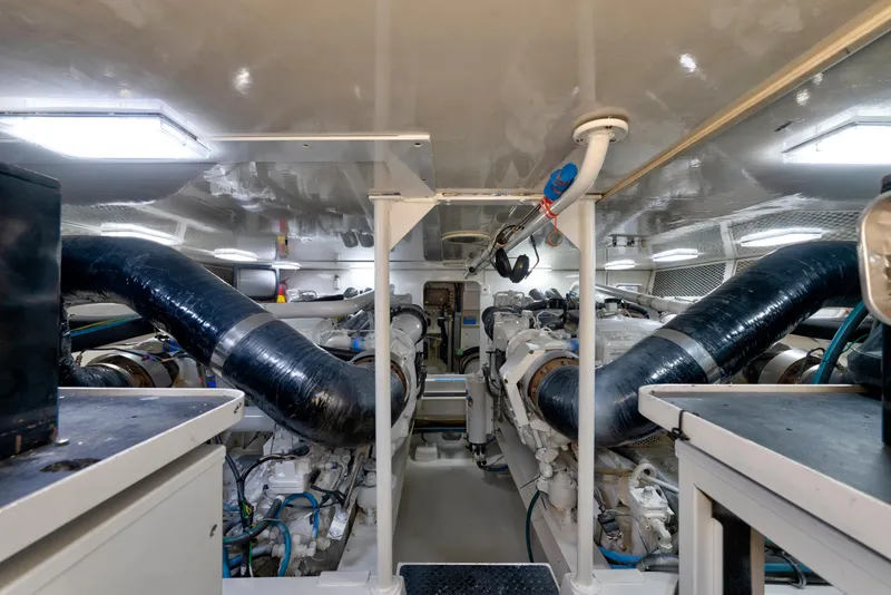 Slide: The Image of Engine room of a 2002 Viking Convertible yacht, featuring dual engines and ventilation systems. - 34