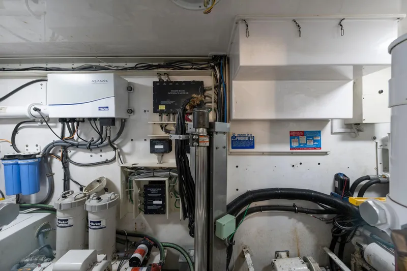 Slide: The Image of Engine room of a 2002 Viking Convertible boat, featuring various mechanical components and wiring. - 36