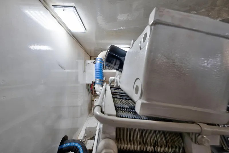 Slide: The Image of Engine room of a 2002 Viking Convertible yacht, featuring mechanical components and piping. - 39