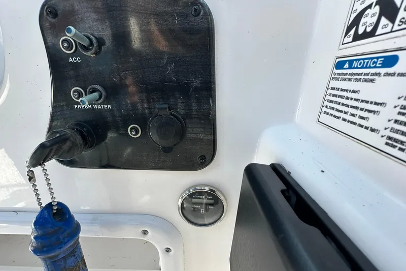 Slide: The Image of Control panel of a 2016 Hurricane SunDeck 187 OB boat with switches and instructions. - 12