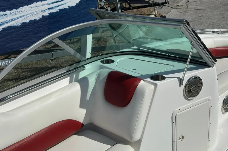 Slide: The Image of 2016 Hurricane SunDeck 187 OB boat interior with red and white seating, windshield, and speaker. - 13