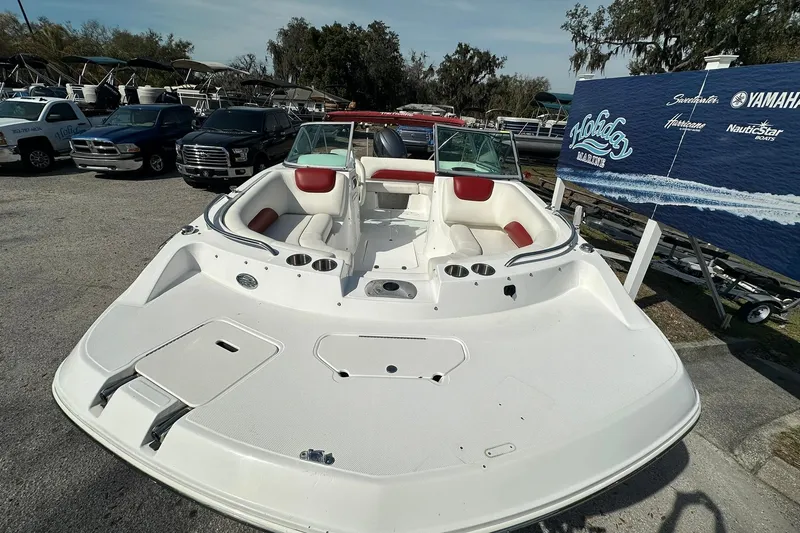 Slide: The Image of 2016 Hurricane SunDeck 187 OB boat with red and white seating, parked outdoors. - 5