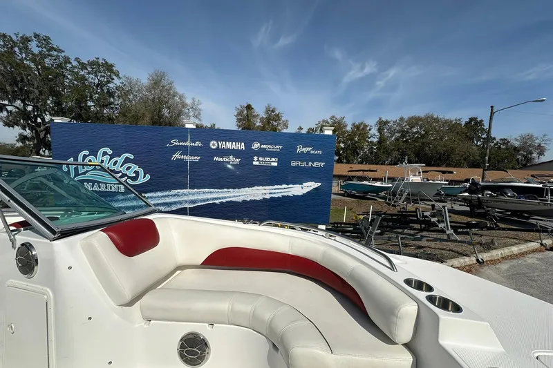 Slide: The Image of 2016 Hurricane SunDeck 187 OB boat with red and white seating, displayed outdoors. - 8