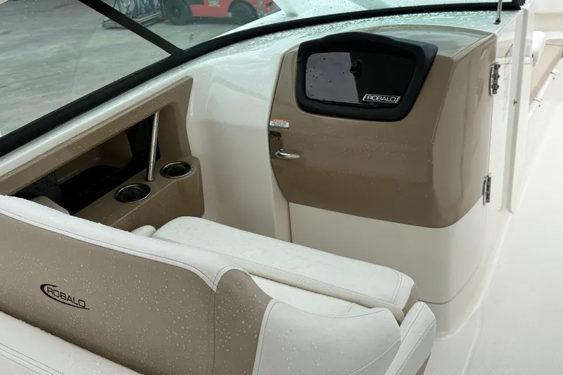 Slide: The Image of 2024 Robalo R317 Dual Console interior with beige seating and cup holders. - 15
