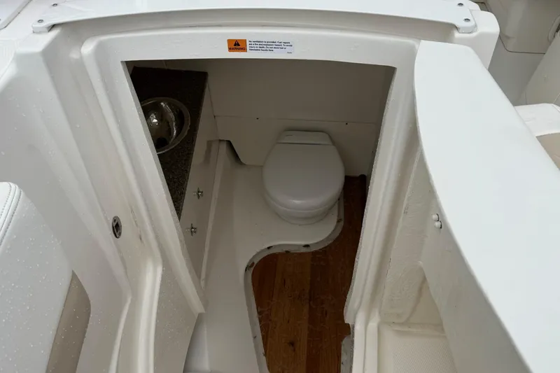 Slide: The Image of 2024 Robalo R317 Dual Console boat interior bathroom with toilet and sink. - 17