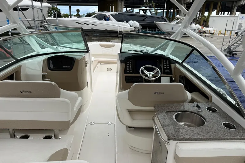 Slide: The Image of 2024 Robalo R317 Dual Console boat interior with helm, seating, and sink. - 23