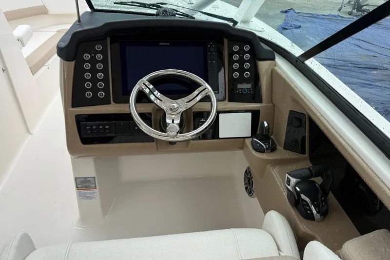 Slide: The Image of 2024 Robalo R317 Dual Console boat cockpit with steering wheel and control panel. - 25