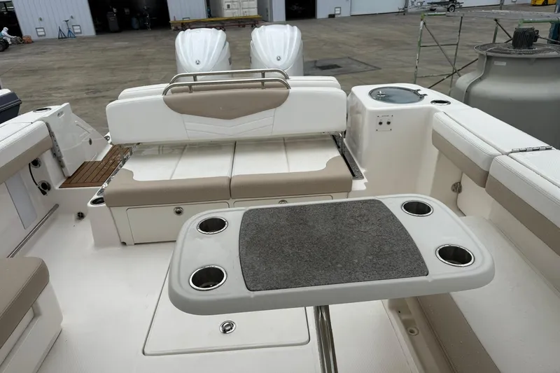 Slide: The Image of 2024 Robalo R317 Dual Console boat interior with seating and table setup. - 3