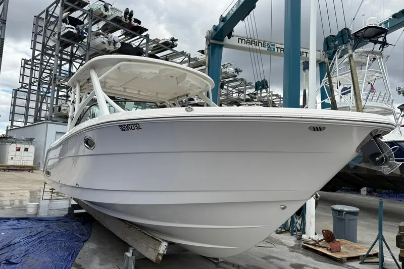 Slide: The Image of 2024 Robalo R317 Dual Console boat in a marina, ready for launch. - 5