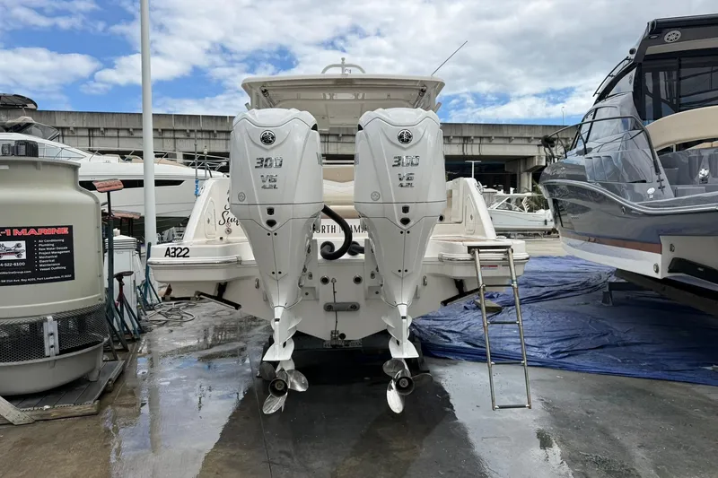 Slide: The Image of 2024 Robalo R317 Dual Console boat with twin 300 V6 engines at a marina. - 7