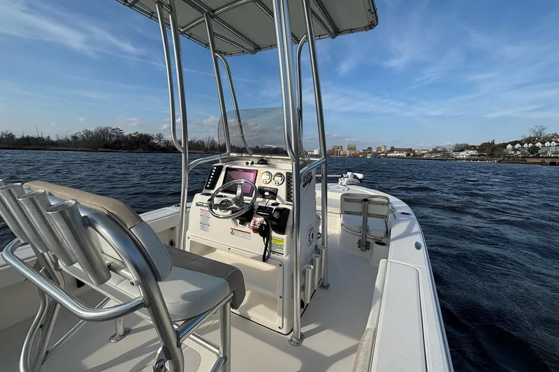 Slide: The Image of 2020 Robalo 226 Cayman boat on water, featuring helm and seating under clear sky. - 13