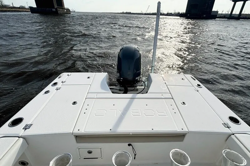 Slide: The Image of 2020 Robalo 226 Cayman boat on water, rear view with engine and open sea. - 14
