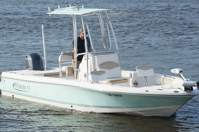 Slide: The Image of 2020 Robalo 226 Cayman boat cruising on water with T-top and outboard motor. - 6