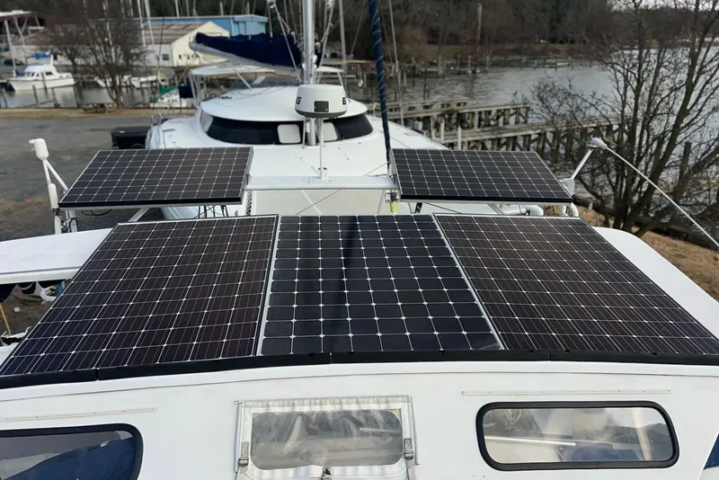 Slide: The Image of Soubise Plaisance Freydis 46 catamaran with solar panels, docked near a serene waterfront. - 5