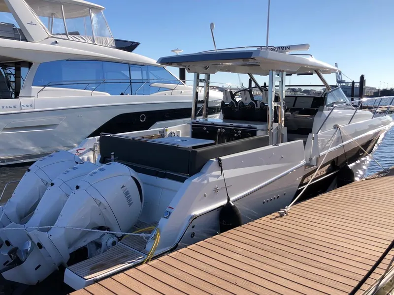 Slide: The Image of 2024 Jeanneau Leader 12.5 WA boat docked with twin outboard engines. - 0