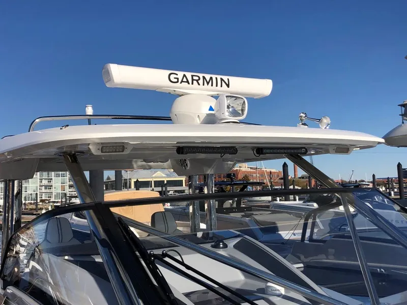 Slide: The Image of 2024 Jeanneau Leader 12.5 WA boat with Garmin radar, docked under clear blue sky. - 12