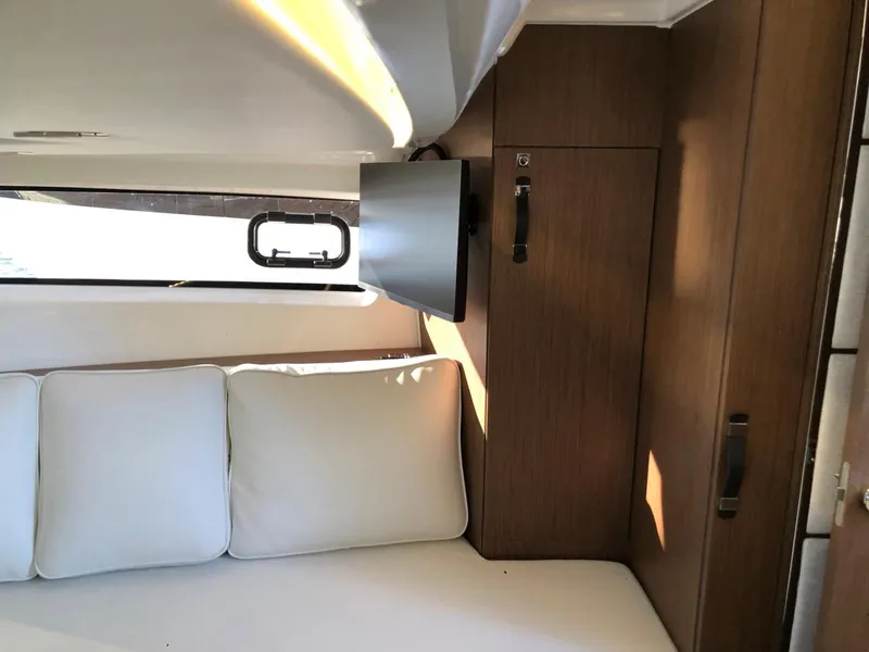 Slide: The Image of Interior of 2024 Jeanneau Leader 12.5 WA with cozy seating and wooden cabinetry. - 26