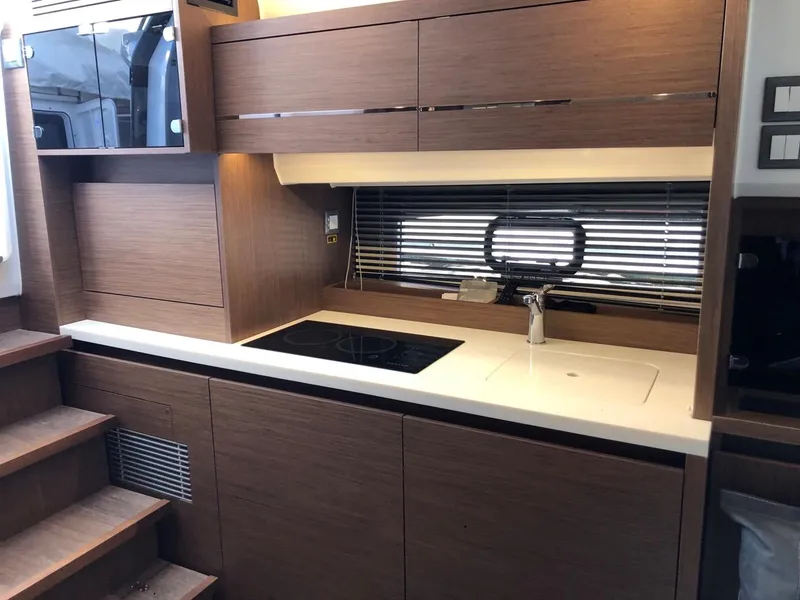 Slide: The Image of 2024 Jeanneau Leader 12.5 WA yacht interior kitchen with modern wood cabinetry and sleek design. - 32