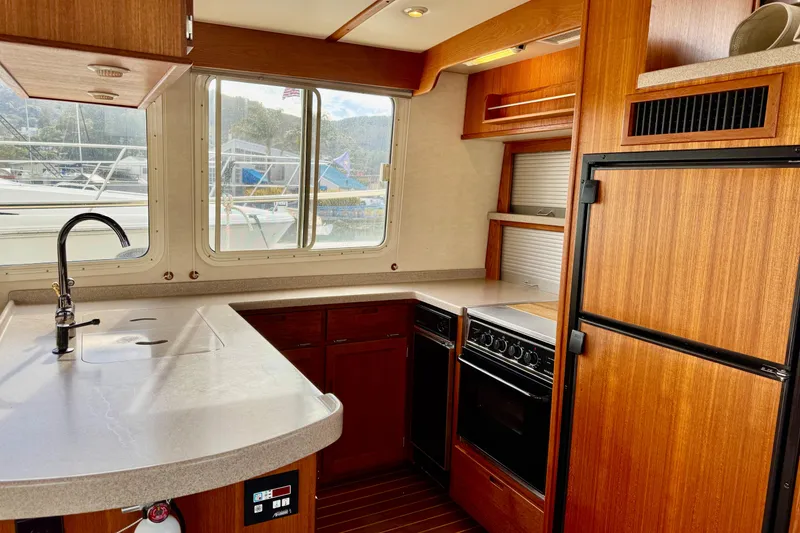 Slide: The Image of 2004 Nordic Tug 42 interior kitchen with wood cabinetry and modern appliances. - 12