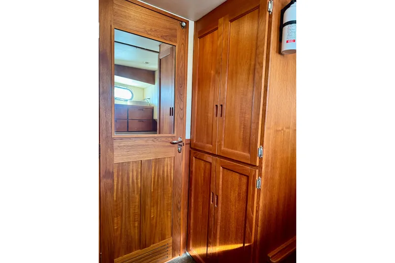 Slide: The Image of Wooden interior of 2004 Nordic Tug 42, featuring a door with mirror and cabinets. - 21