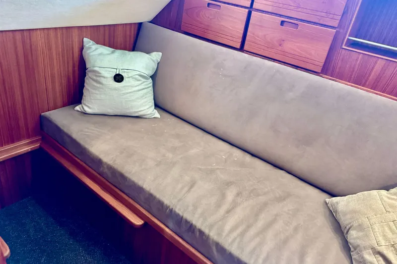 Slide: The Image of Cozy interior of 2004 Nordic Tug 42 with cushioned seating and wooden cabinetry. - 23