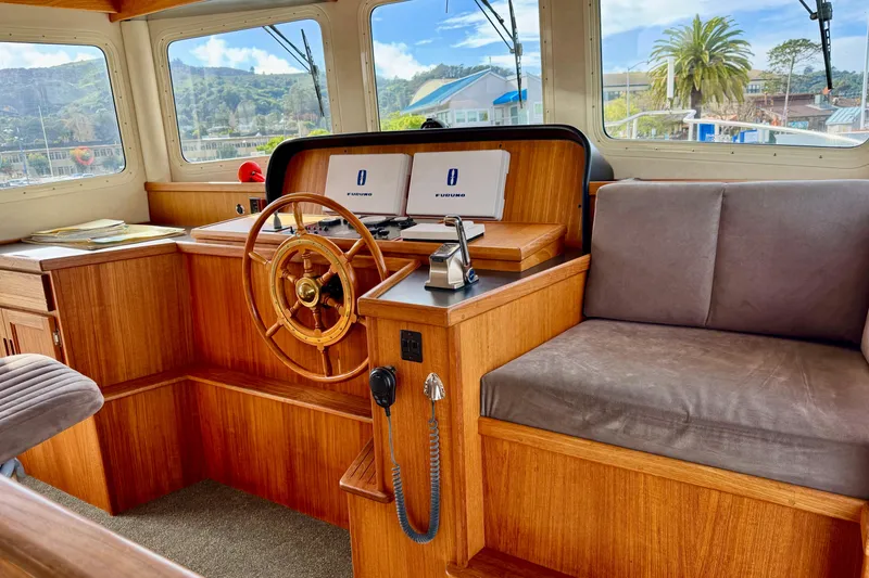 Slide: The Image of 2004 Nordic Tug 42 helm with wooden steering wheel and navigation equipment. - 29