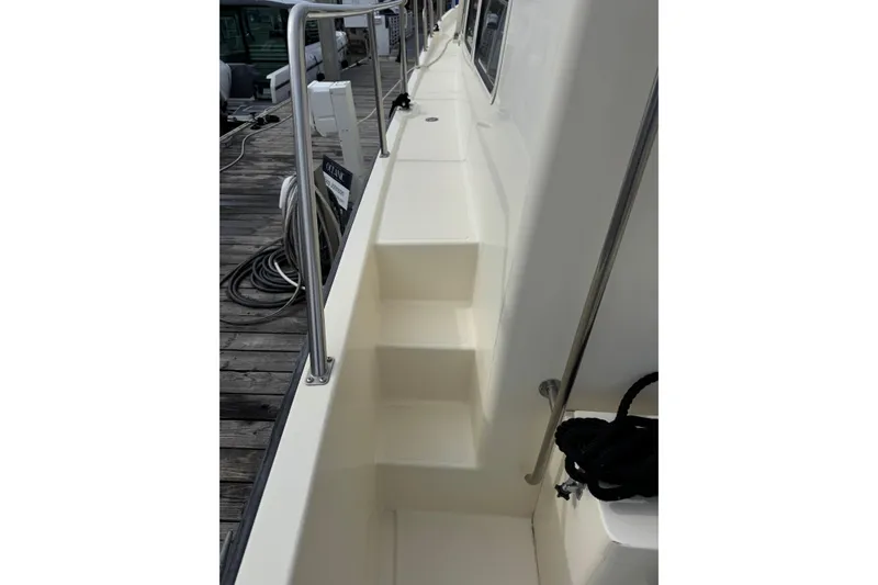 Slide: The Image of Side deck of a 2004 Nordic Tug 42 with railing and dock view. - 46