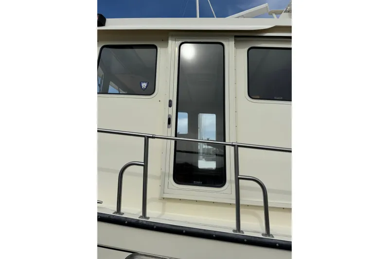 Slide: The Image of 2004 Nordic Tug 42 boat exterior with windows and railing. - 49