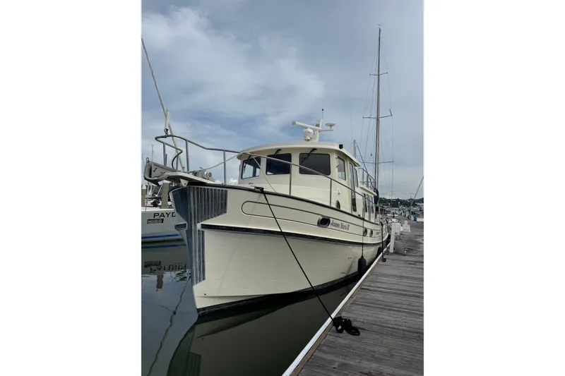 Slide: The Image of 2004 Nordic Tug 42 docked at marina under cloudy sky. - 5